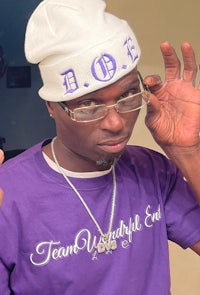 a man wearing a purple t - shirt and glasses